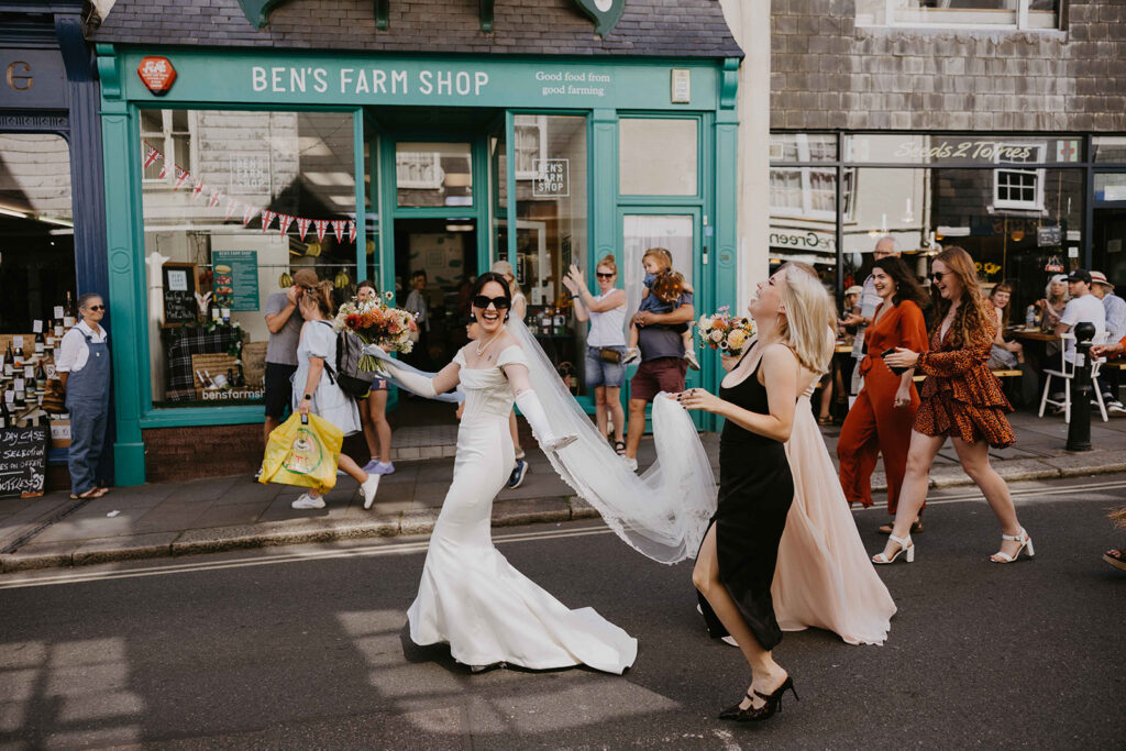 A wedding party dancing down Totnes High Street